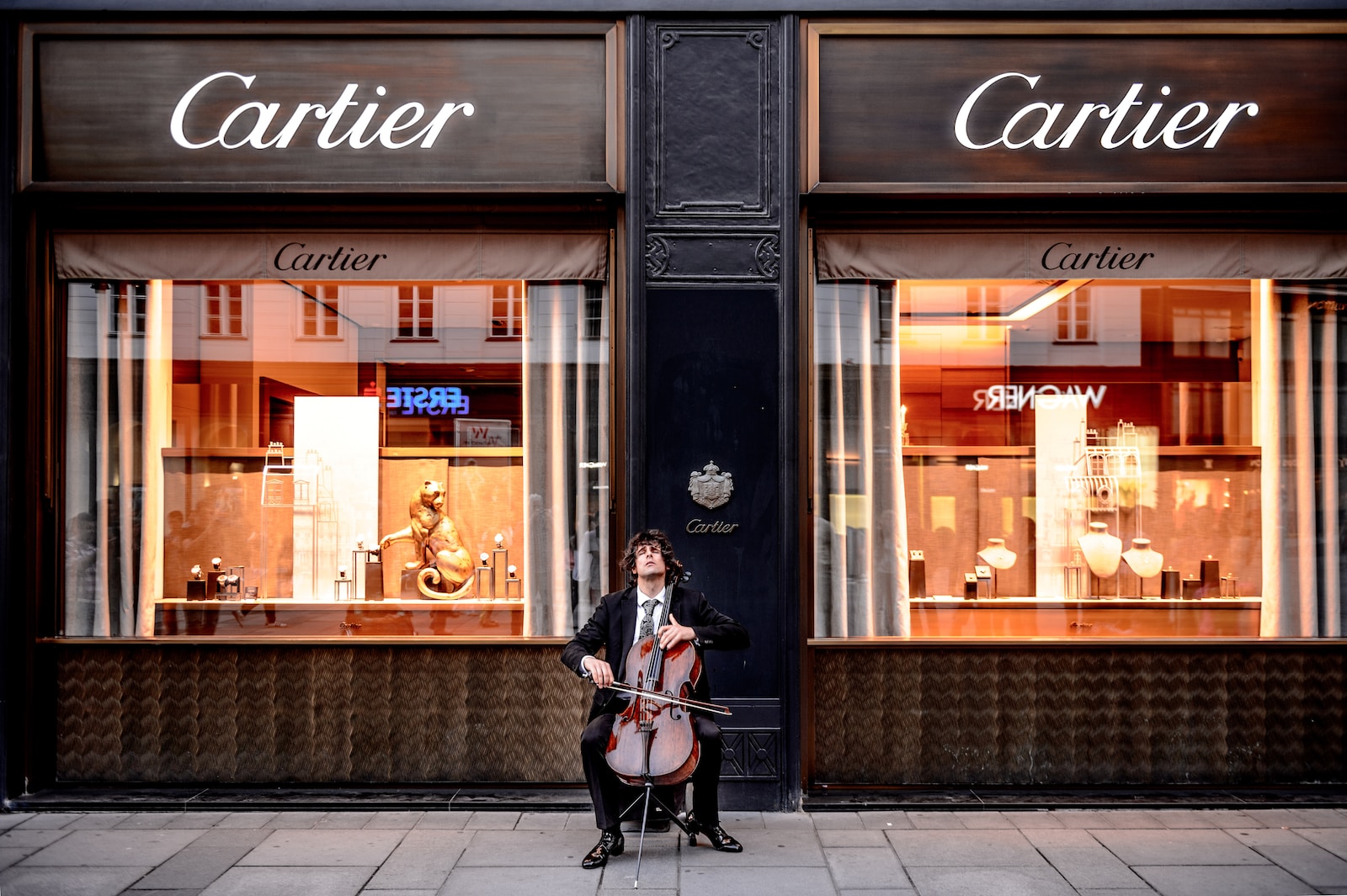 man playing cello in front of store